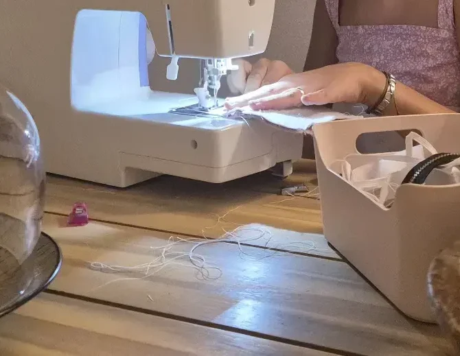 Manos cosiendo en la máquina de coser